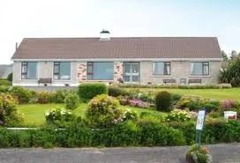 Charming Irish cottage with lush garden, promoting Mayo Dark Sky Festival's serene countryside accommodation.