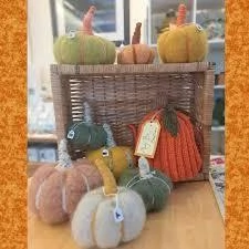 Colourful knitted pumpkins displayed in a wicker basket at Mayo Dark Sky Festival. Cozy autumn decor.