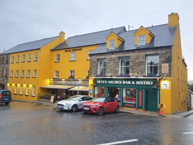 Hotel Newport and Seven Arches Bar, vibrant buildings on a rainy day in County Mayo, ideal for Mayo Dark Sky Festival visitors.