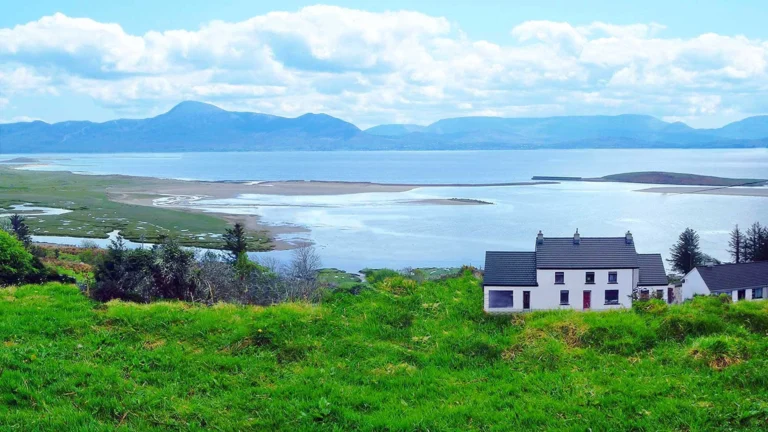 Scenic view of Clew Bay, Ireland with mountains, houses, and lush greenery, perfect for Mayo Dark Sky Festival backdrop.