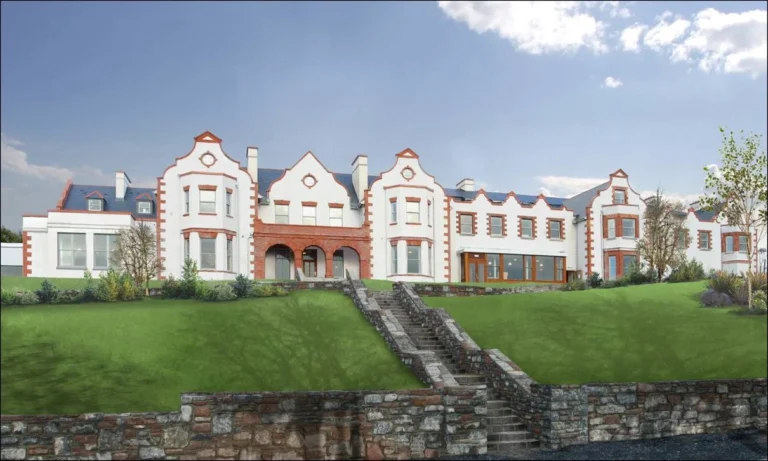 Historic white and red building with stairs and green lawn, venue for Mayo Dark Sky Festival, under a bright, clear sky.