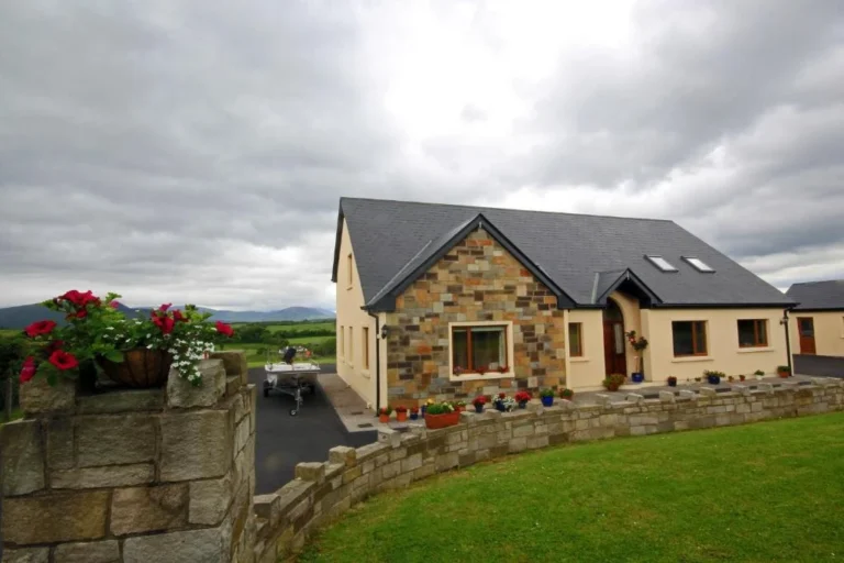 Modern country house amidst lush Irish landscape under cloudy sky, perfect for Mayo Dark Sky Festival accommodation.